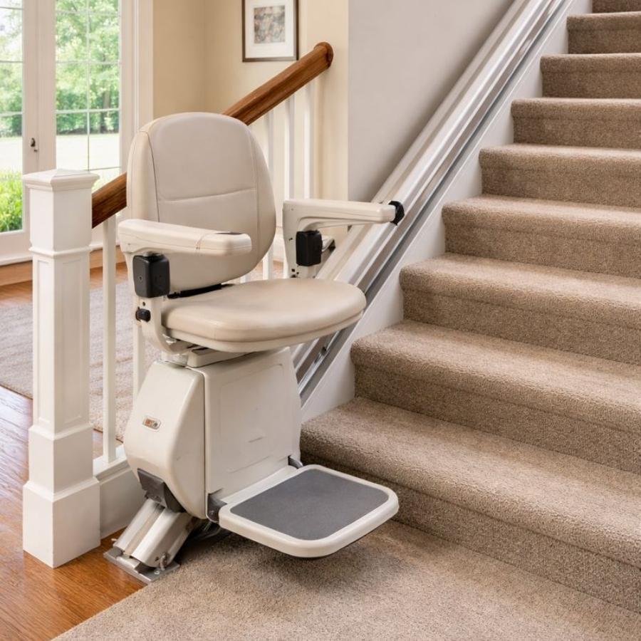Indoor residential chair lift system with a tan padded seat and armrests installed on a carpeted staircase for home mobility in Mount Pleasant, SC