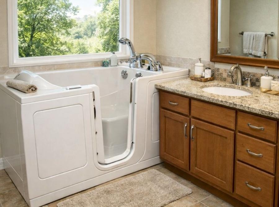 
Luxurious white walk-in soaking tub with an outward-opening door, integrated bench seat, and handheld showerhead installed in a Hinesville, GA bathroom.