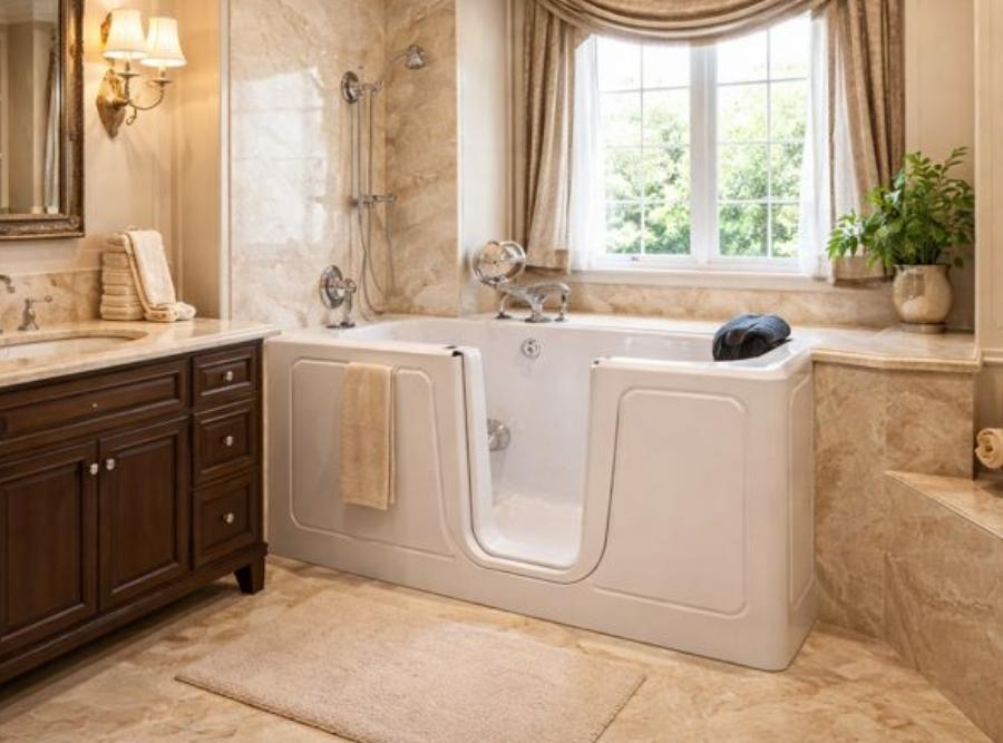 
Luxurious white walk-in soaking tub with an outward-opening door, integrated bench seat, and handheld showerhead installed in a Savannah, GA bathroom.