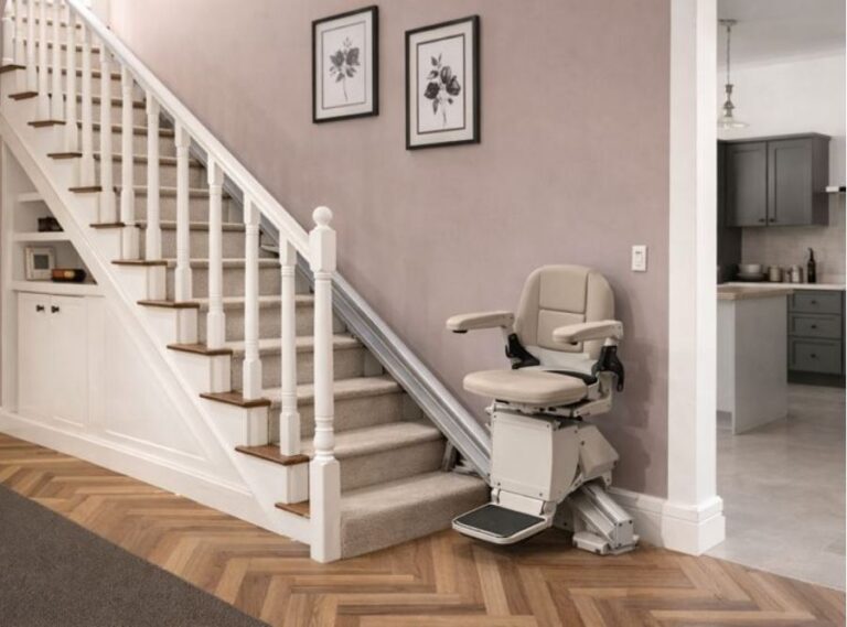 Contemporary home interior with a carpeted staircase fitted with a motorized stairlift chair, providing a safe aging‑in‑place mobility solution beside the kitchen.