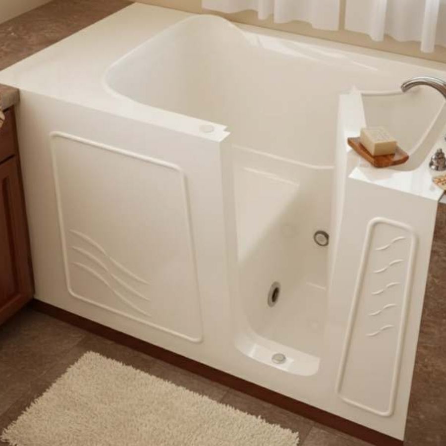 Jekyll Island GA walk-in tub with low step-in entry, deep soaking design, textured side panels and nearby counter space in a compact neutral bathroom for safe senior accessible bathing.